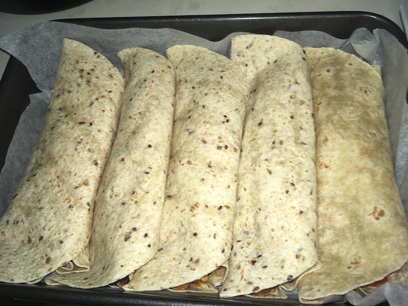 five rolled wrap breads in a roasting pan