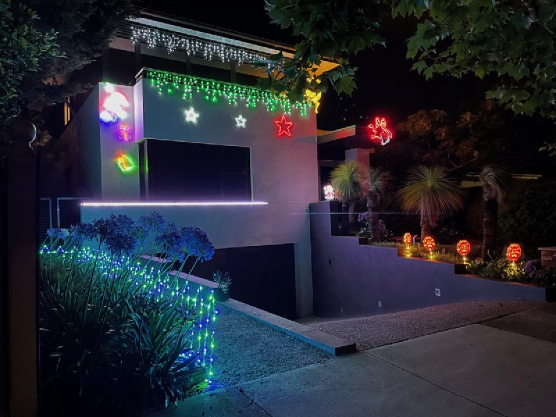 a modern blocky house completely decked out in flashy Christmas lights