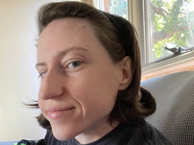 a selfie, half-profile angle, showing shoulder-length hair with a curl at the end