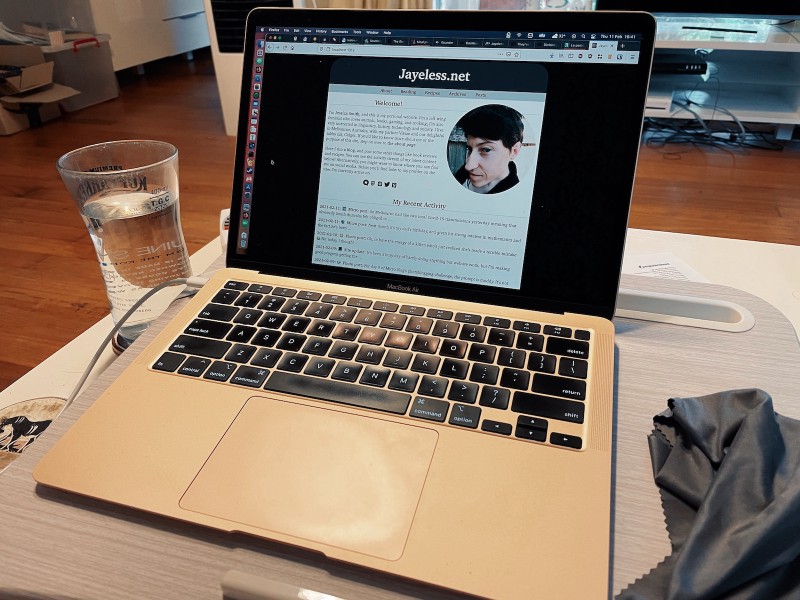 a photo of a rose gold MacBook Air on a light-coloured lap desk