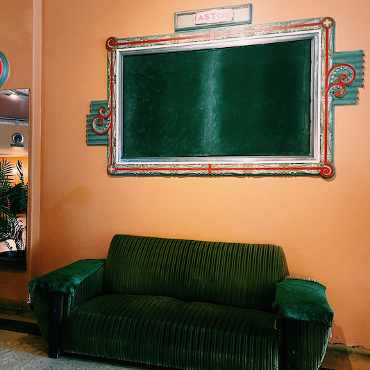 a couch and a mirror downstairs at the Astor