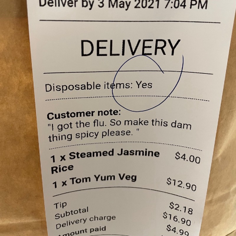 an Uber Eats receipt on the side of a cardboard bag. Customer notes say 'I got the flu. So make this dam thing spicy please.'